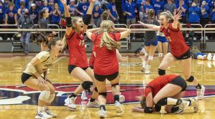 Players celebrate on the court after clinching the state championship.