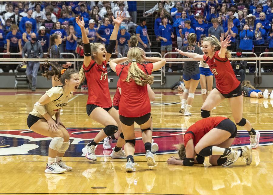 Players celebrate on the court after clinching the state championship.